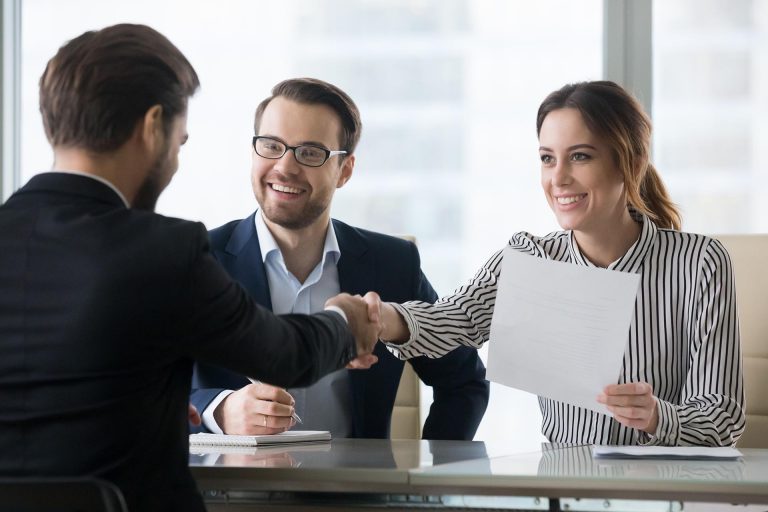 Happy employers shake hand of male job candidate, congratulating with given position, satisfied HR managers happy to hire applicant handshake greeting at team. Successful good interview concept