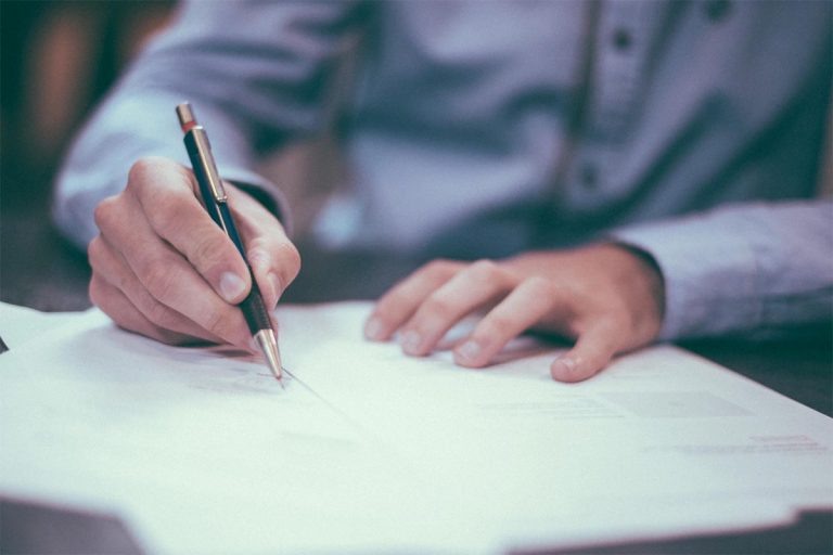 man writing on paper