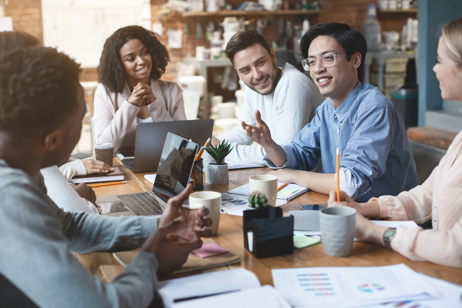 Close up of young creative international group of people having business meeting in office